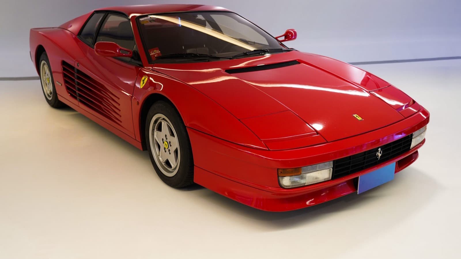 Une voiture de sport rouge exposée dans un showroom