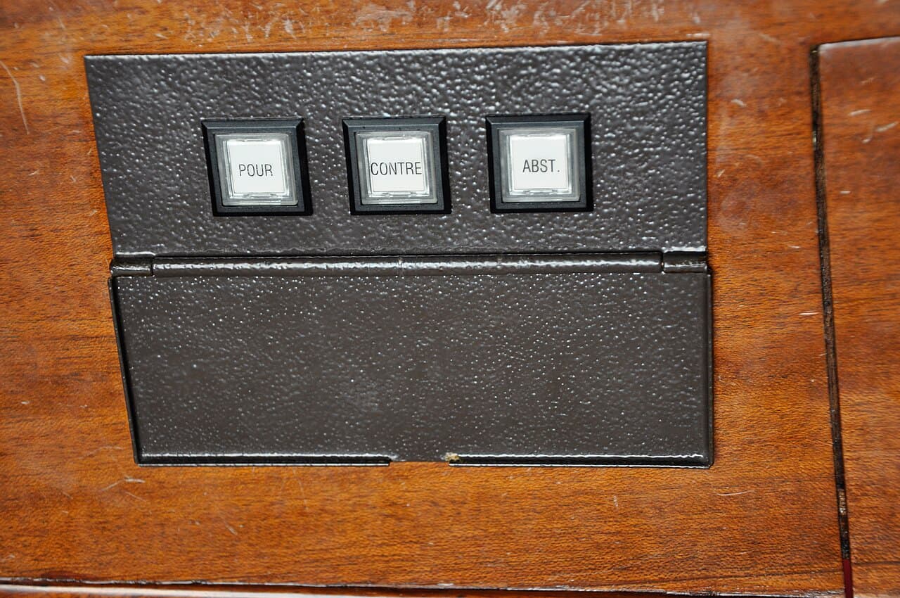 Boutons Pour, Contre et Abstention sur le pupitre de vote d’un député — photo d’illustration