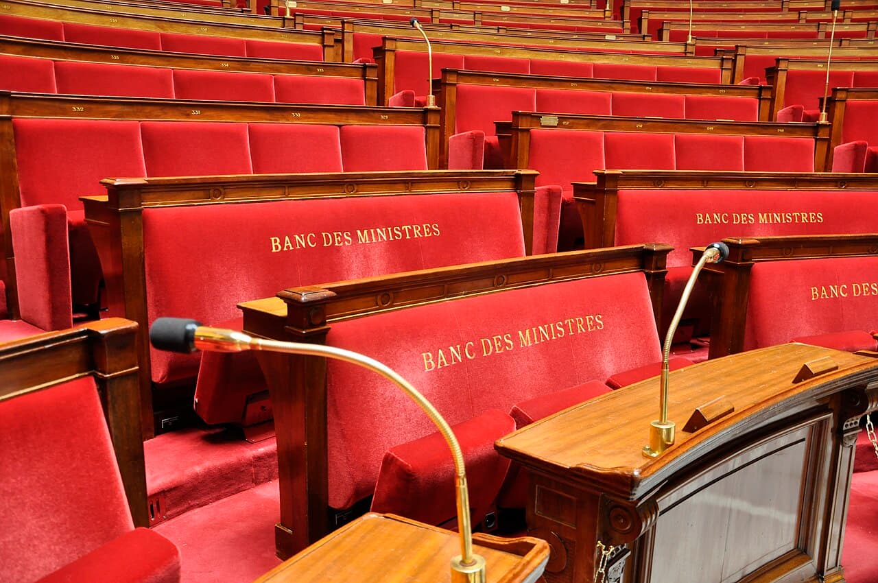 Microphones et sièges rouges du banc des ministres à l’Assemblée nationale — photo d’illustration