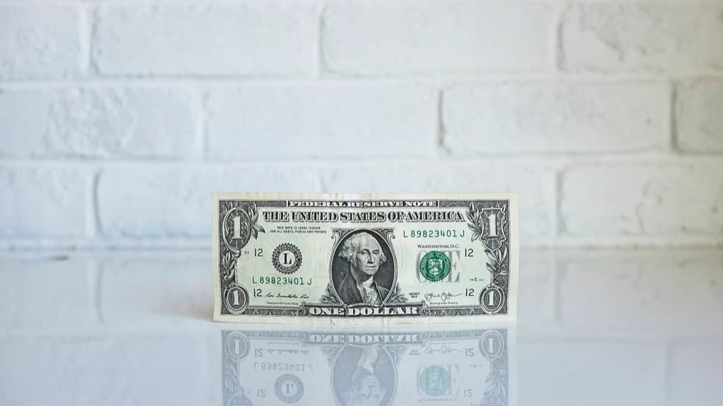 Un billet d'un dollar posé contre un mur