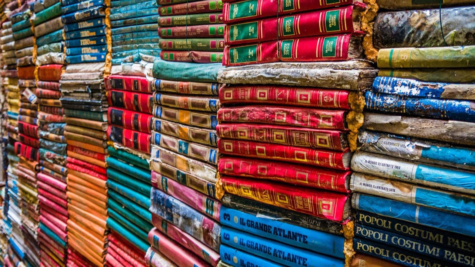 Des piles de livres anciens aux reliures colorées