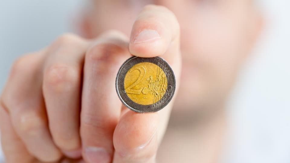 Une pièce de deux euros tenue entre deux doigts