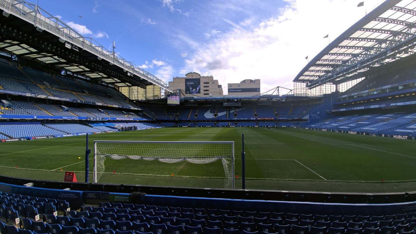 Un stade de football vu depuis les tribunes, pelouse et but au premier plan